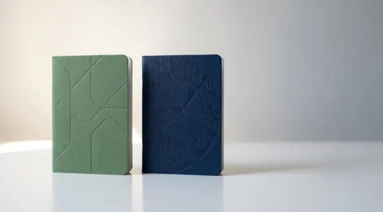 Deux livrets d'épargne bancaire français côte à côte sur une surface épurée symbolisant la comparaison entre produits financiers durables
